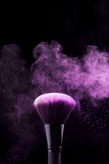 Makeup brush with neon fuchsia powder mist