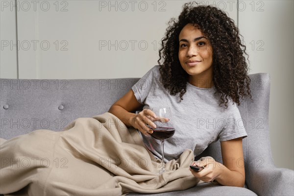 Woman couch watching tv drinking wine