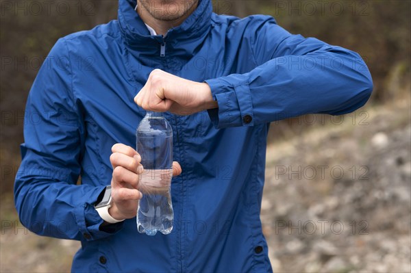 Man holding bottle water nature