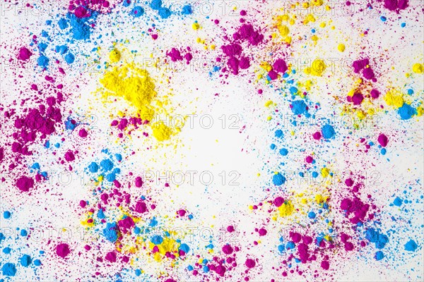 Splatter yellow pink blue holi color powder white background