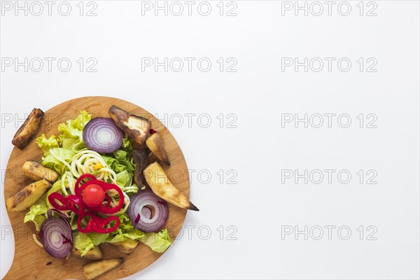 Chopped vegetables roasted potato wooden cutting board white background