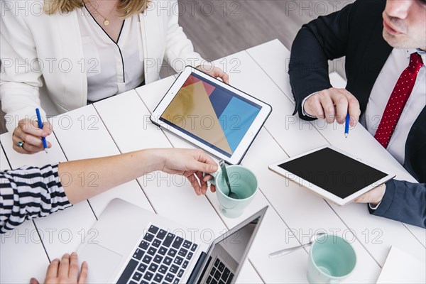 Crop businesspeople with gadgets desk