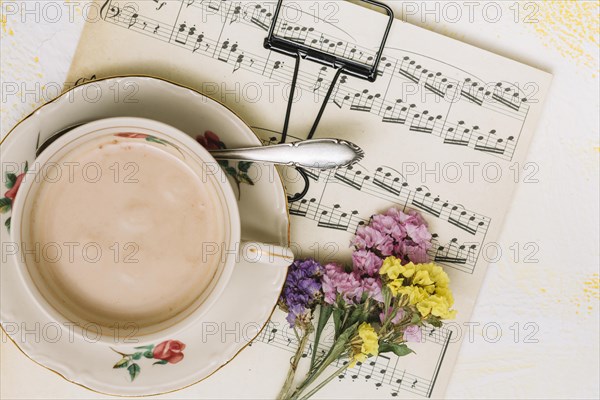Small flowers branches with coffee cup music sheet