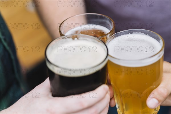 Friend s hand toasting glass alcoholic drinks