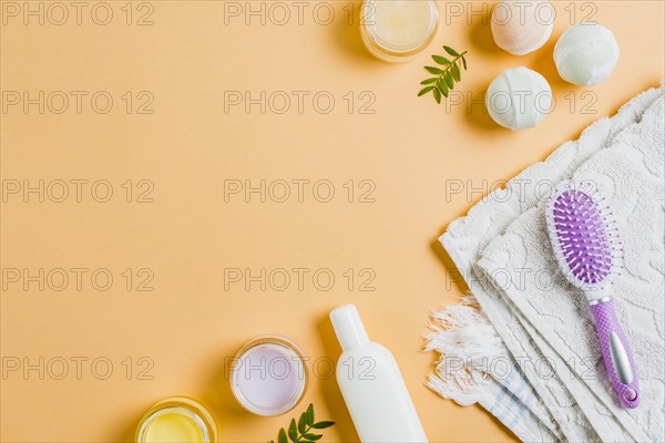 Towel moisturizers hairbrush bath bomb colored background