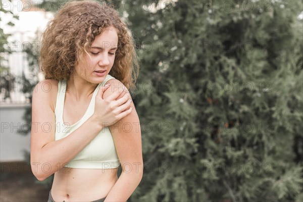 Close up female athlete having pain shoulder