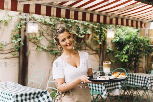 Smiling waitress holding tray