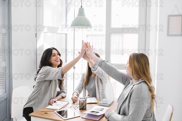 Women high fiving table