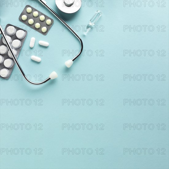 Stethoscope with blister packed medicines against blue background