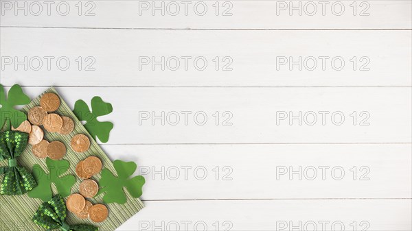 Composition bow ties near coins green paper clovers board