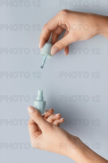 Close up hands holding blue nail polish