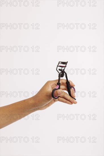 Female hand with eyelash curler