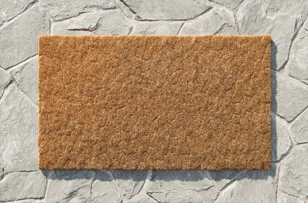 Overhead of blank doormat on the rock tile porch