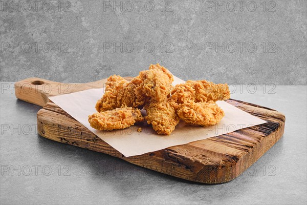 Deep fried chicken wings in breading on parchment paper