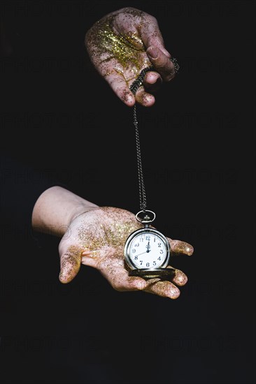 Man with glitters showing pocket watch