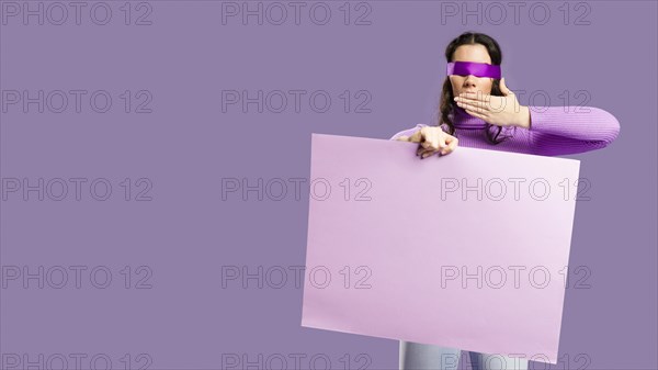 Woman having her eyes tied holding empty cardboard does speak