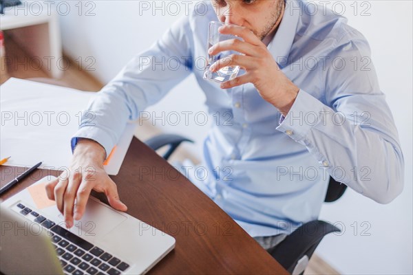 Man drinking water sitting table