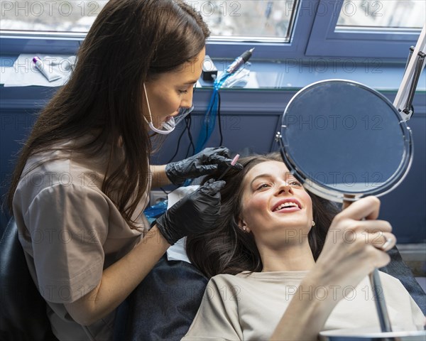 Beautician doing eyebrow treatment her client