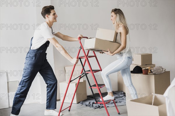 Man holding ladder woman climb