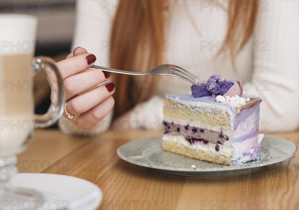 Close up woman with fork delicious blueberry cake slice plate wooden table