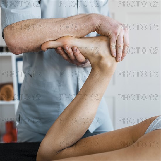 Male physiotherapist female patient during massage session