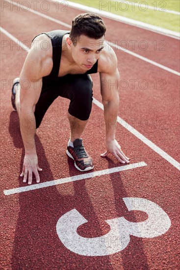 Muscular male young runner start line