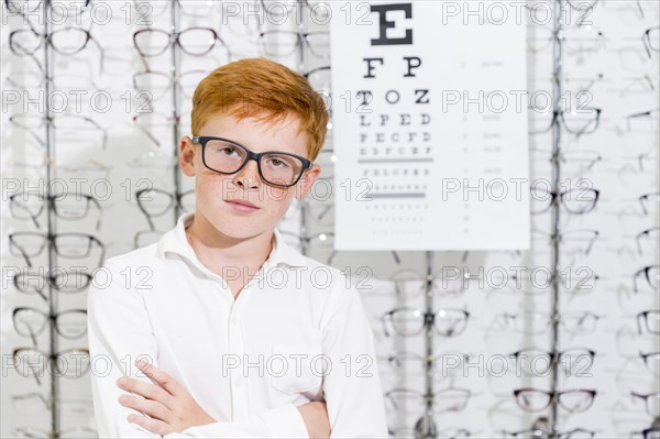 Portrait innocent boy with arm crossed posing optics store