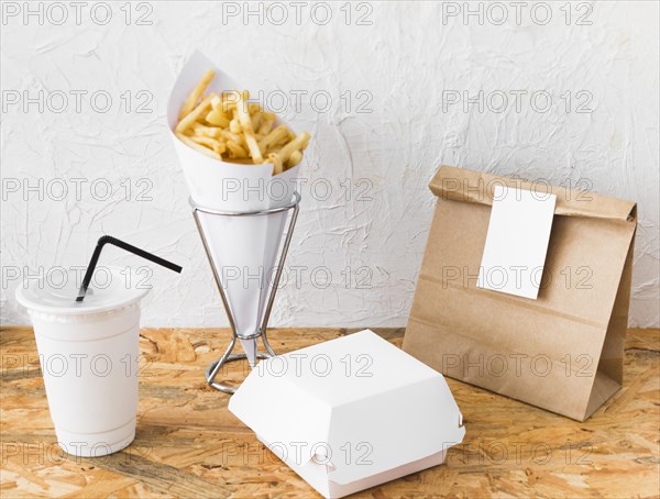 French fries disposal cup food parcel wooden surface