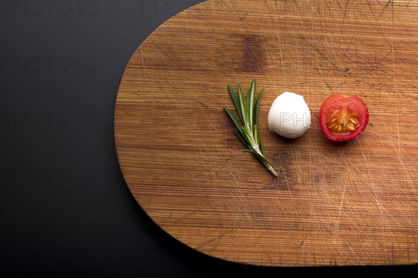 Close up fresh cheese rosemary half tomato chopping board