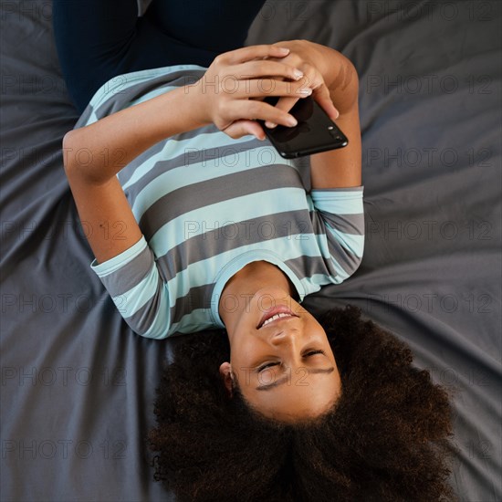 Medium shot smiley girl with smartphone