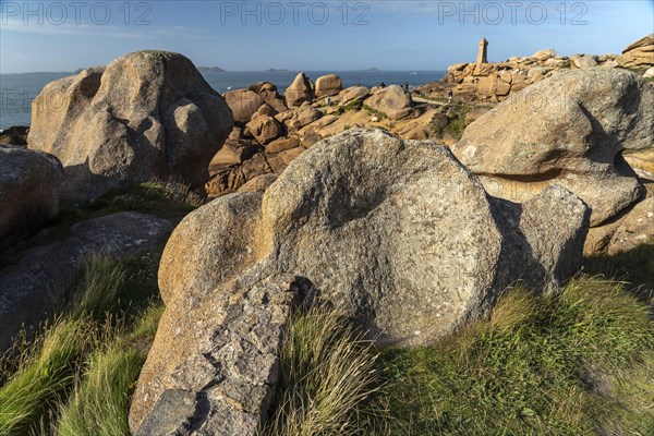 The rocks of the pink granite coast Cote de Granit Rose and the lighthouse Phare de Ploumanac'h near Ploumanac'h