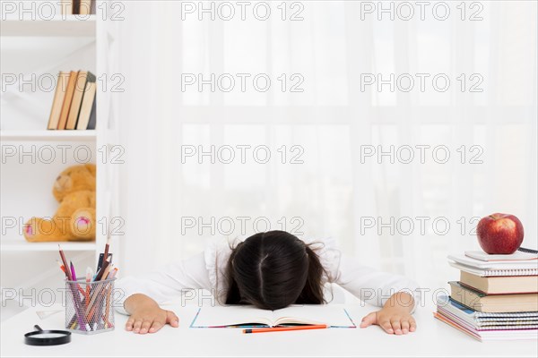 Tired schoolgirl lying copybook