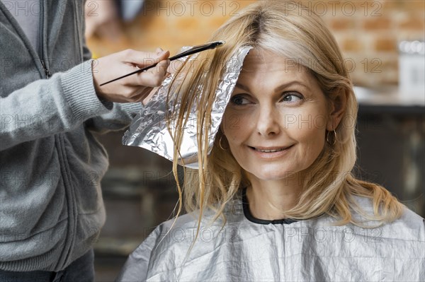 Woman getting her hair dyed by hairdresser home