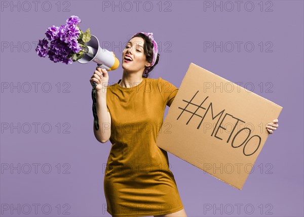 Woman talking megaphone holding cardboard with me too sign