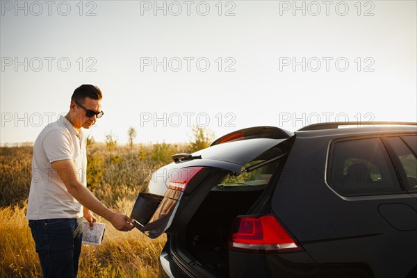 Young man opening trunk