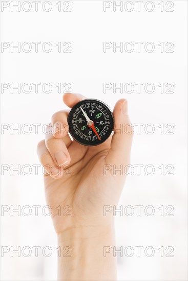 Close up person s hand holding compass isolated white background