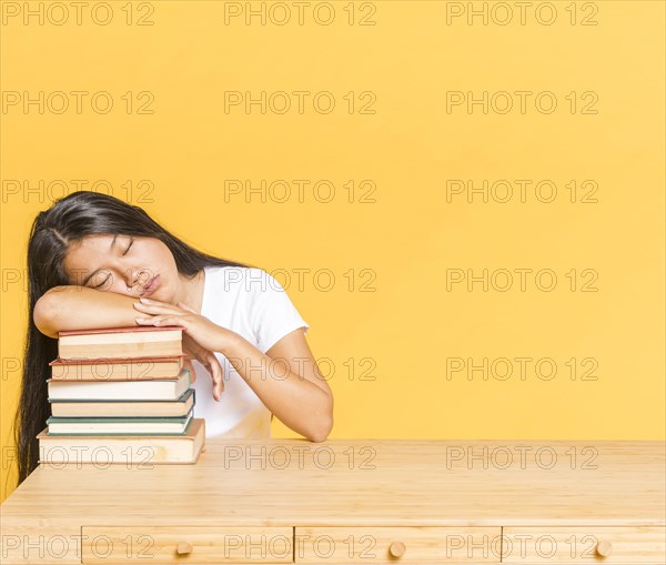 Pile books desk woman sleeping