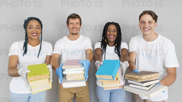 Smiley people holding bunch books donate them