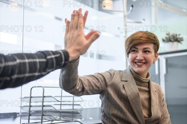 Woman sitting wheelchair high five