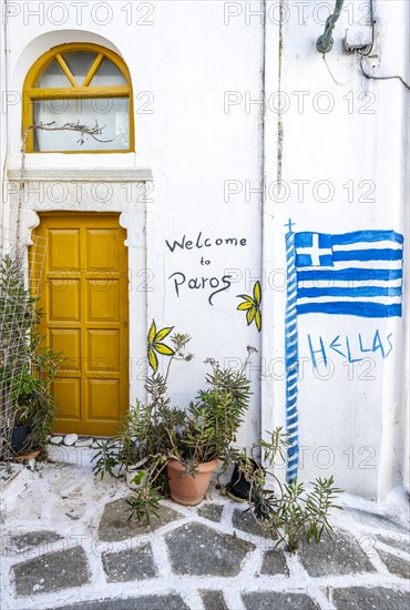 Painted house wall with inscription Welcome to Paros and Hellas with Greek flag