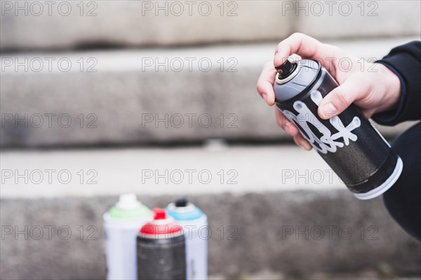 Close up man s hand holding graffiti spray bottle