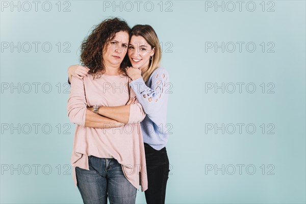 Woman embracing displeased mother