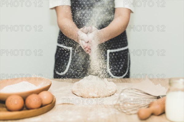 Woman making bread pouring flour