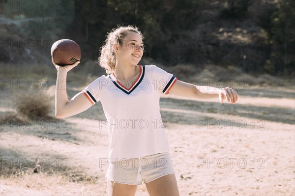 Cheerful teen schoolgirl playing rugby