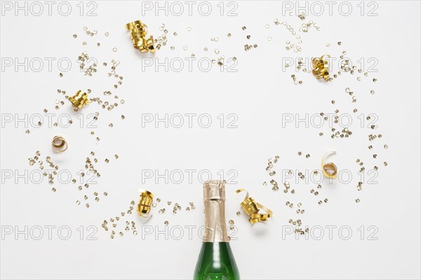 Top view champagne bottle with golden ribbons confetti