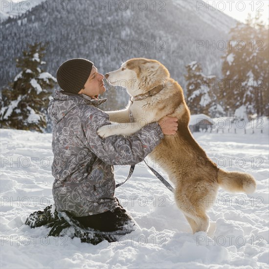 Full shot man playing with dog