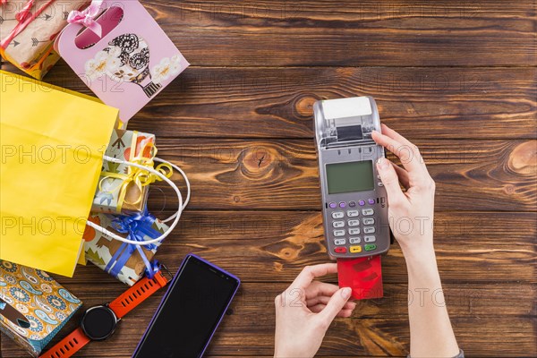 Human hands using credit card swiping machine payment store