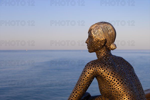 A metal sculpture by artist Carlos de Oliveira Correia looks out over the Atlantic Ocean from the viewing platform on Olhos des Augua beach shortly after sunrise.