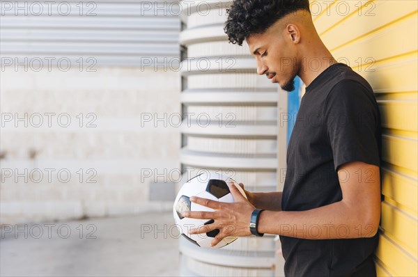 Black man looking down ball hands