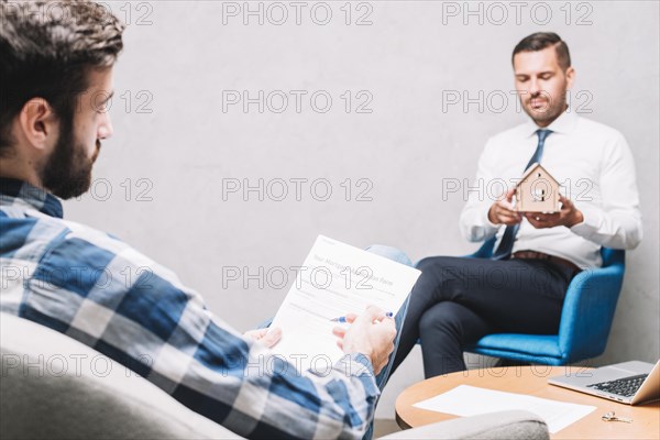 Man reading contract near agent